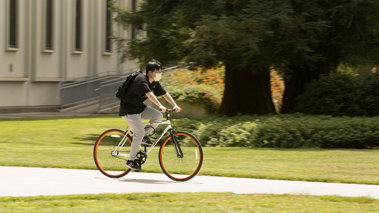 Student on bicycle wearing mask