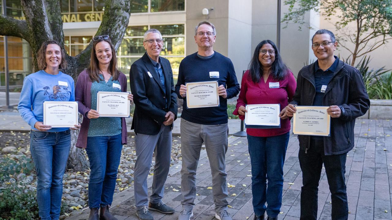 Five award recipients stand outdoors with the dean holding certificates during the CBS 20th anniversary celebration at UC Davis