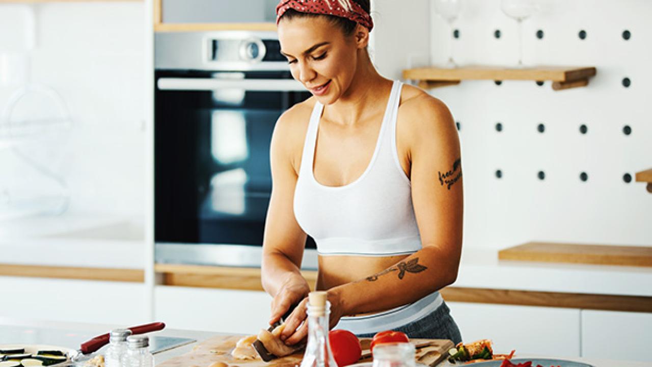 Athletic women in kitchen preparig food