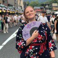 Female student with fan in street festival