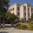 Photo of Green Hall and two masked students walking