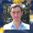 An abstract photograph featuring an individual wearing a light blue shirt. The background consists of lush green foliage, and abstract yellow and blue paint-like smudges adorn the top and bottom edges of the image. 