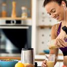 Athletic woman in the kitchen making a smoothie